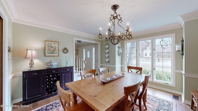 dining area featuring light wood-type flooring, stairs, visible vents, and ornamental molding