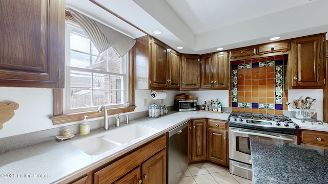 kitchen with stainless steel appliances, light tile patterned flooring, a sink, and recessed lighting