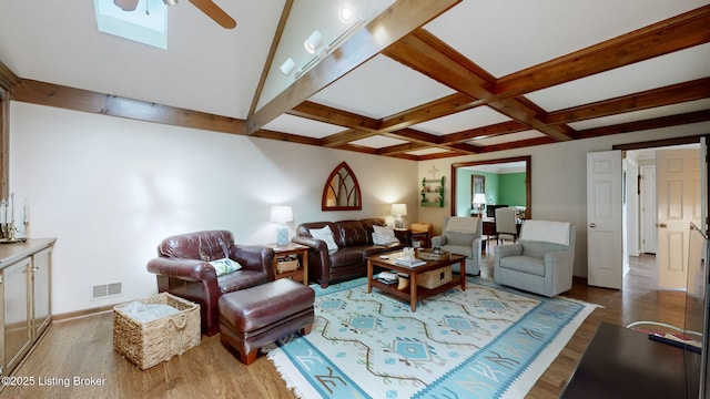 living area with visible vents, coffered ceiling, a ceiling fan, beamed ceiling, and wood finished floors