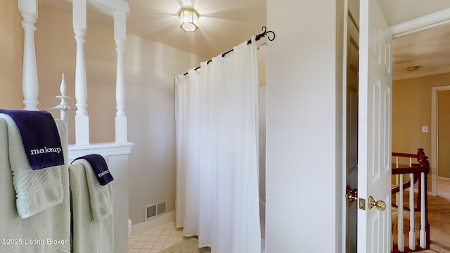 full bath with a shower with shower curtain, visible vents, baseboards, ornamental molding, and tile patterned floors