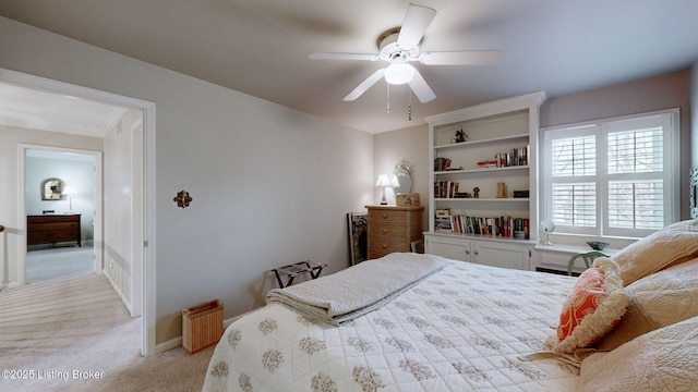 bedroom featuring light carpet, baseboards, and a ceiling fan