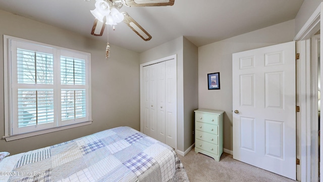 bedroom with baseboards, a closet, a ceiling fan, and light colored carpet