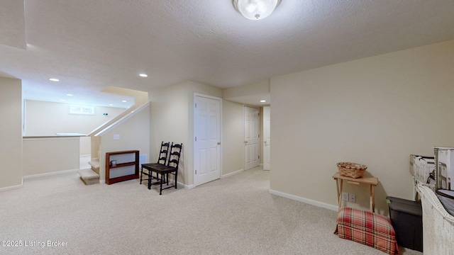 living area featuring baseboards, carpet, stairway, and a textured ceiling