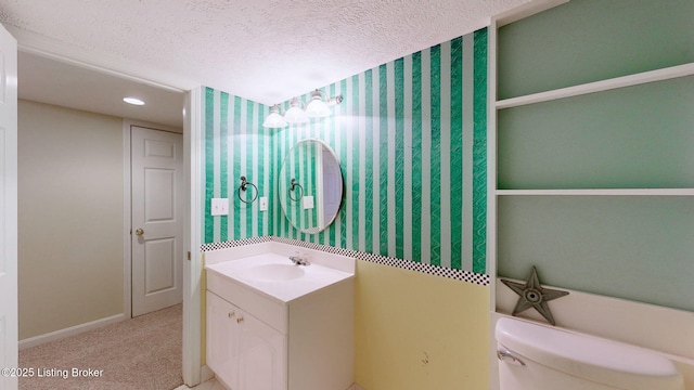 bathroom featuring toilet, wallpapered walls, a textured ceiling, and vanity