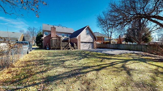 exterior space with a yard, brick siding, fence, and an attached garage