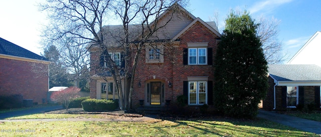 view of front of home with brick siding and a front yard