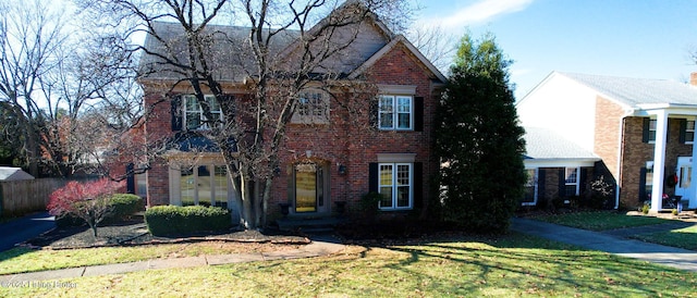 view of front of house featuring brick siding and a front yard