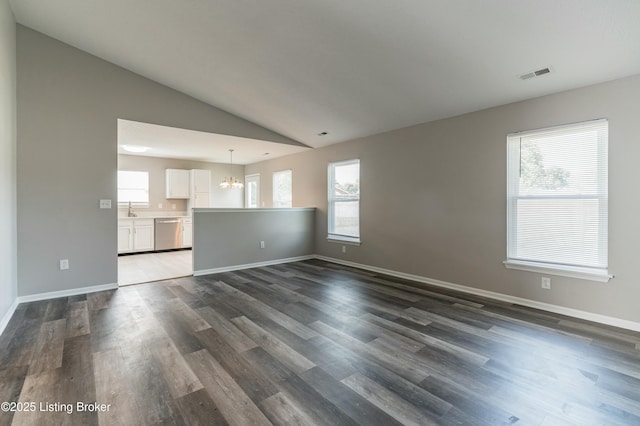 unfurnished living room featuring lofted ceiling, baseboards, visible vents, and dark wood finished floors