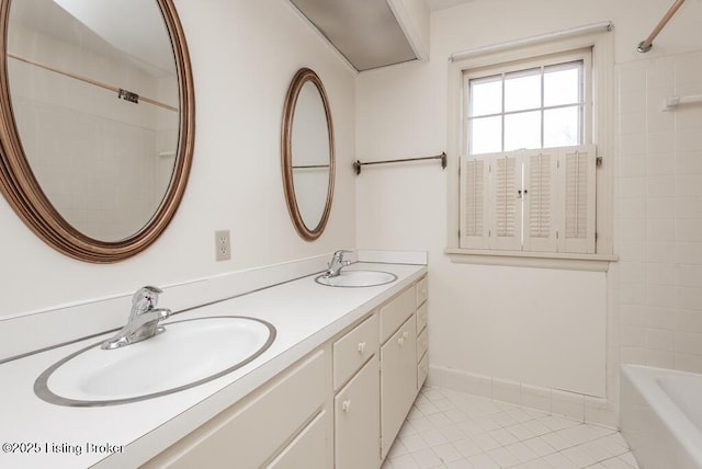 bathroom with baseboards, double vanity, a sink, and tile patterned floors