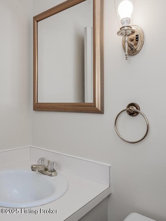 half bathroom featuring toilet and a sink