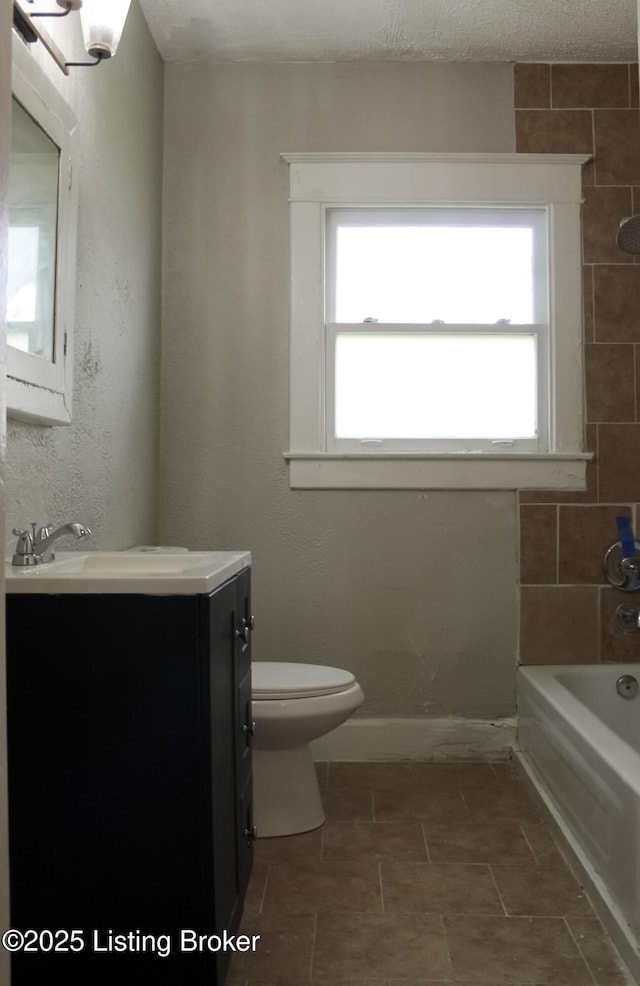 full bathroom featuring baseboards, vanity, toilet, and shower / bathtub combination