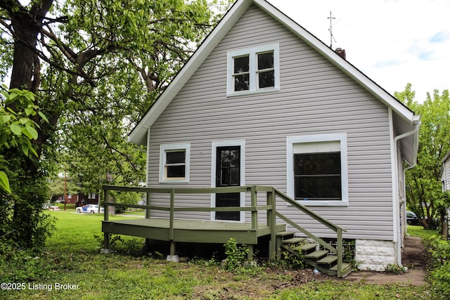 rear view of property featuring a yard and a wooden deck