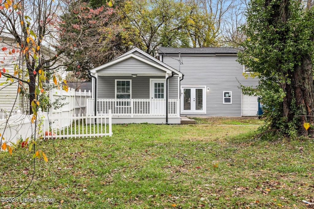 back of house featuring covered porch, a yard, french doors, and fence