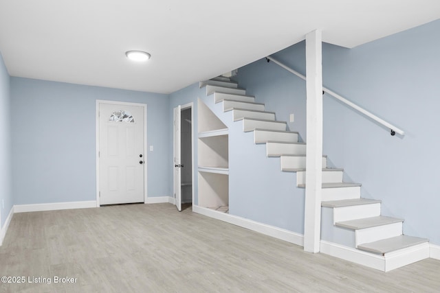 interior space featuring light wood-style flooring, stairway, and baseboards