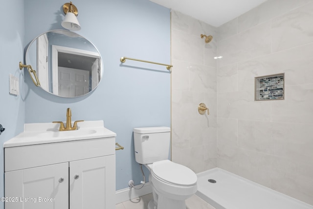 full bath featuring toilet, a tile shower, and vanity