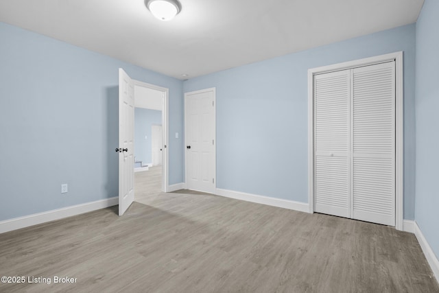 unfurnished bedroom with light wood-style flooring and baseboards