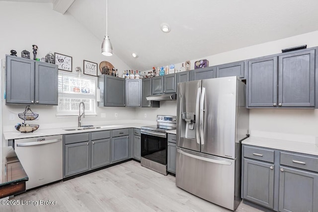 kitchen featuring gray cabinetry, vaulted ceiling with beams, under cabinet range hood, appliances with stainless steel finishes, and a sink