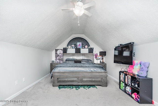 carpeted bedroom with a textured ceiling, a ceiling fan, baseboards, and vaulted ceiling