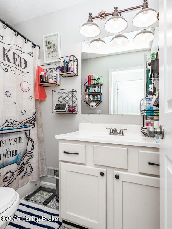 full bathroom featuring vanity, a shower with shower curtain, and toilet