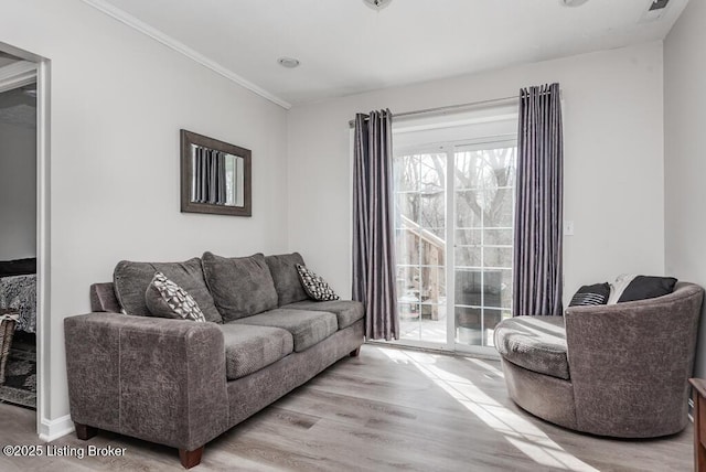 living area with wood finished floors and crown molding