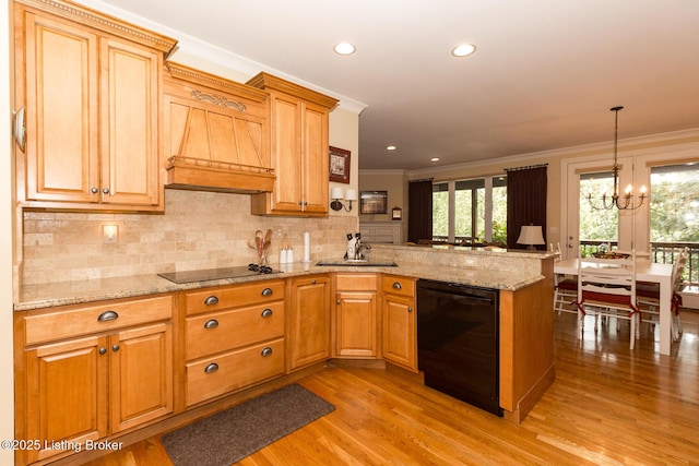 kitchen featuring black appliances, ornamental molding, a sink, a peninsula, and a chandelier