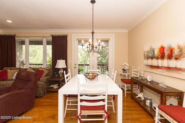 dining room featuring crown molding, recessed lighting, wood finished floors, and a chandelier