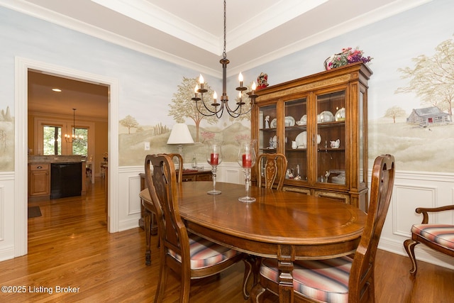 dining area with a chandelier, wainscoting, and ornamental molding