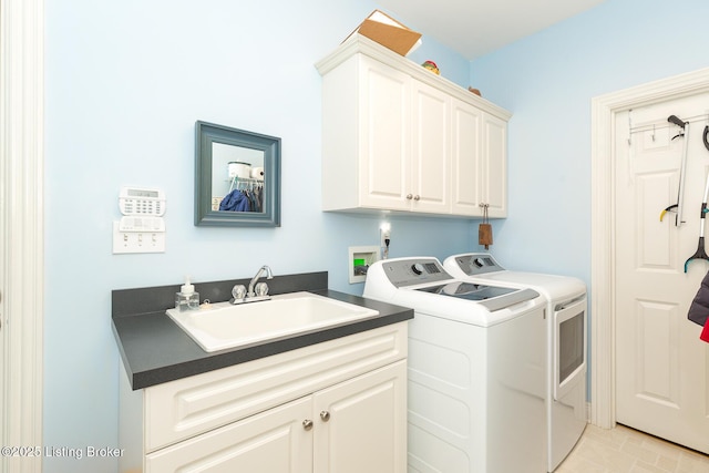 washroom featuring a sink, cabinet space, and washer and clothes dryer