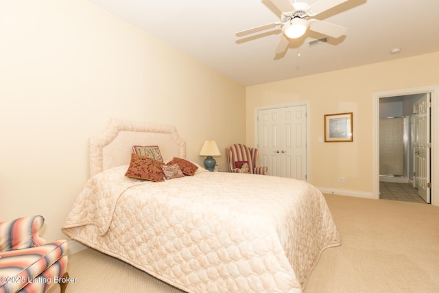 carpeted bedroom with visible vents, ceiling fan, baseboards, ensuite bathroom, and a closet