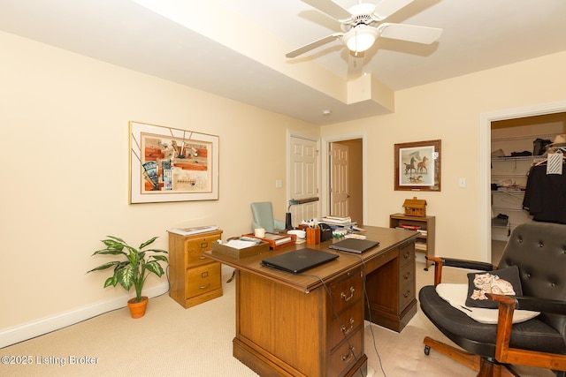 home office featuring light carpet, baseboards, and ceiling fan