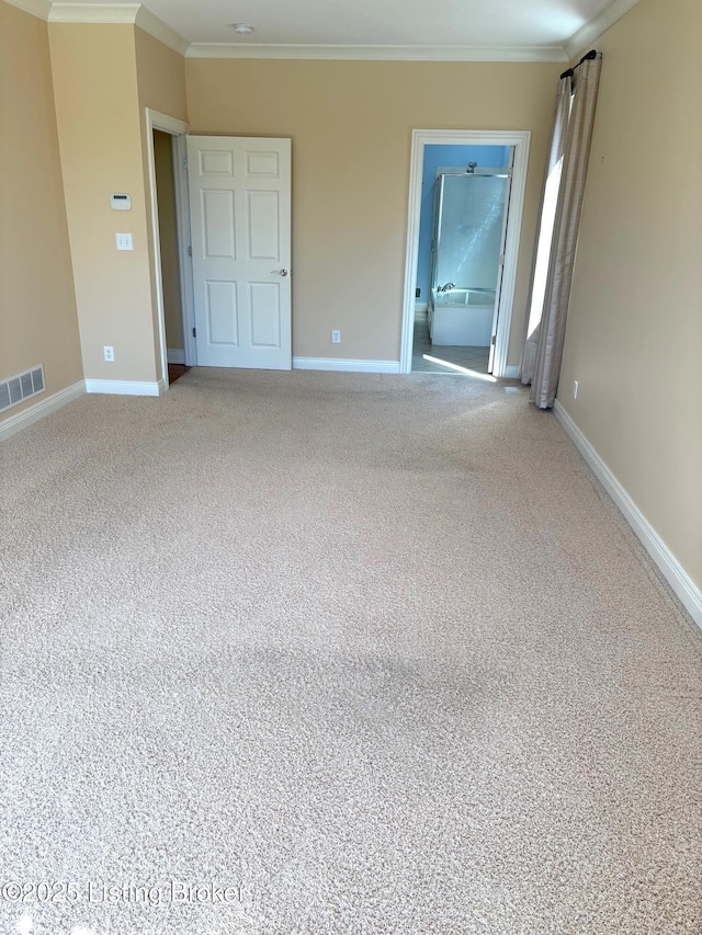 carpeted empty room with baseboards, visible vents, and ornamental molding