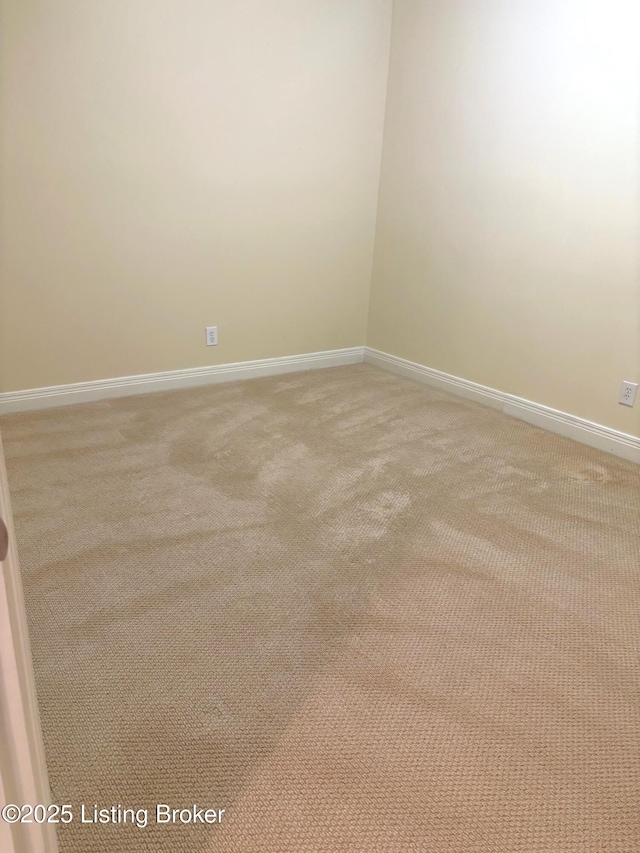 empty room with baseboards and light colored carpet