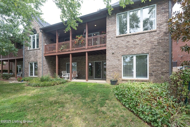 rear view of house featuring brick siding and a yard