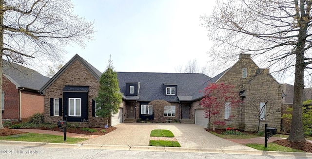 french country style house featuring brick siding, an attached garage, and driveway