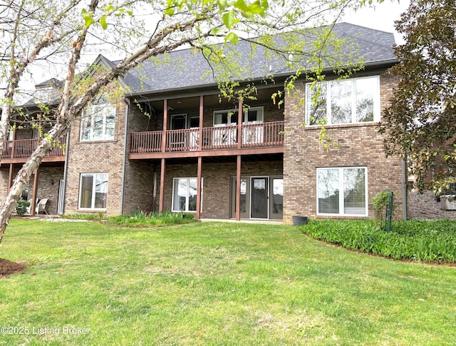 back of house with a wooden deck, brick siding, a yard, and a shingled roof