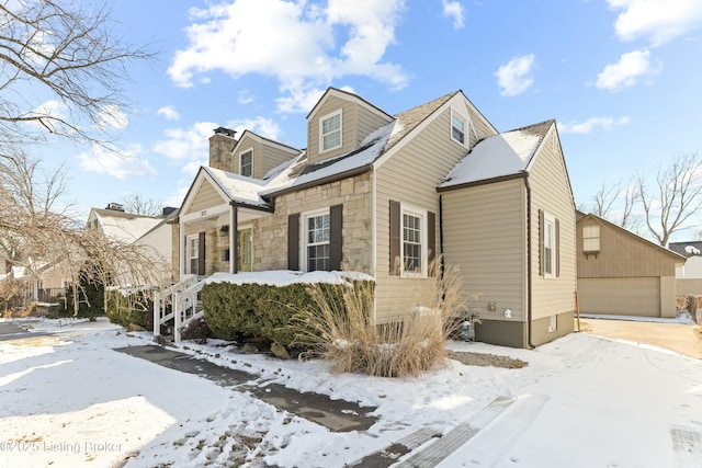 view of front of property with a garage, stone siding, and a chimney