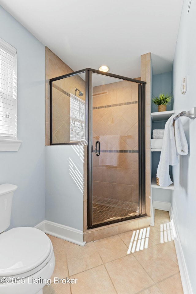 full bathroom featuring a wealth of natural light, a stall shower, tile patterned flooring, and toilet