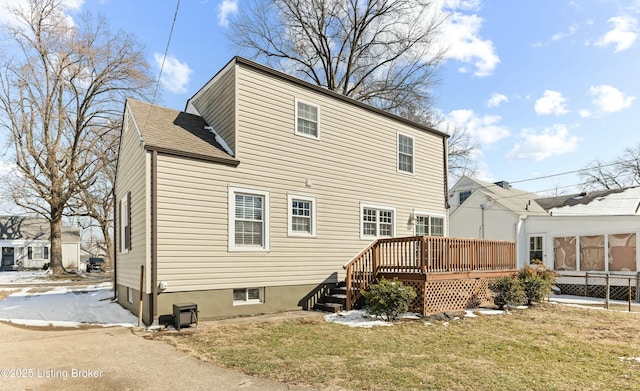 back of property featuring roof with shingles, a lawn, and a wooden deck