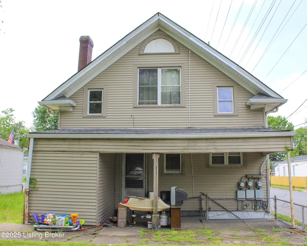 rear view of house featuring fence