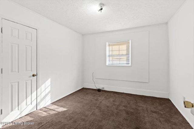 unfurnished room with dark colored carpet and a textured ceiling