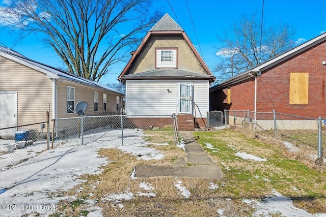 back of property with entry steps, driveway, and fence private yard