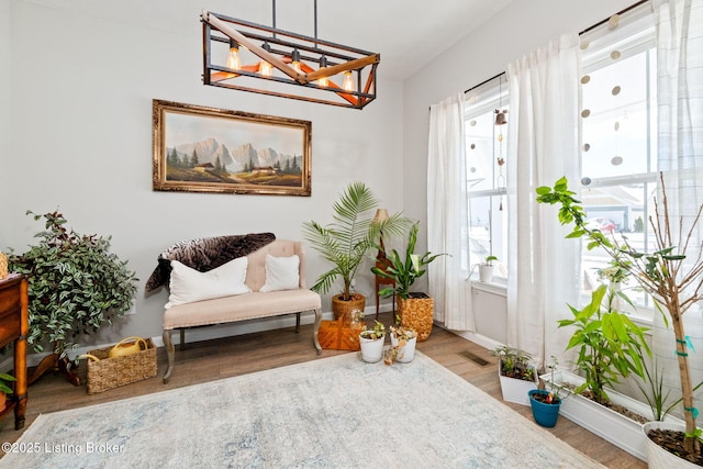 living area featuring baseboards, plenty of natural light, visible vents, and light wood-style floors