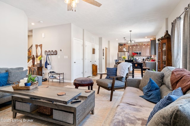 living room featuring a ceiling fan, light wood-type flooring, baseboards, and recessed lighting