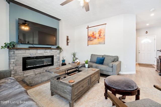 living room featuring a fireplace, recessed lighting, light wood-style floors, ceiling fan, and baseboards