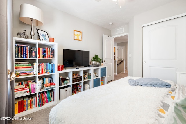 carpeted bedroom with visible vents and a closet