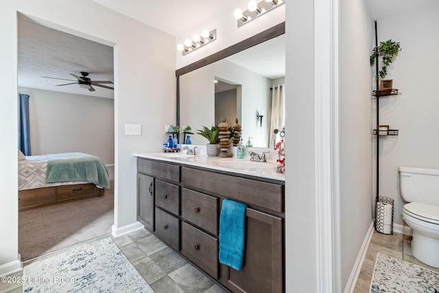 full bath with ensuite bathroom, double vanity, a sink, and toilet