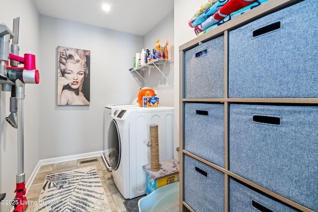 laundry area featuring laundry area, baseboards, and washer and clothes dryer