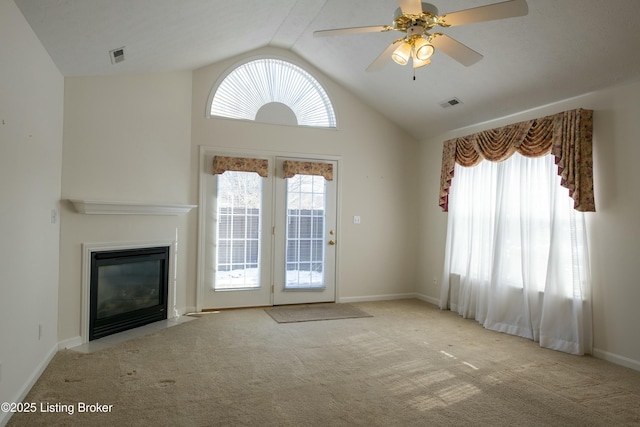 unfurnished living room featuring carpet floors, visible vents, a fireplace with flush hearth, a ceiling fan, and baseboards