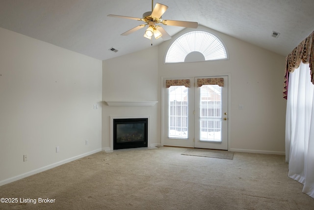 unfurnished living room with visible vents, baseboards, ceiling fan, carpet, and vaulted ceiling