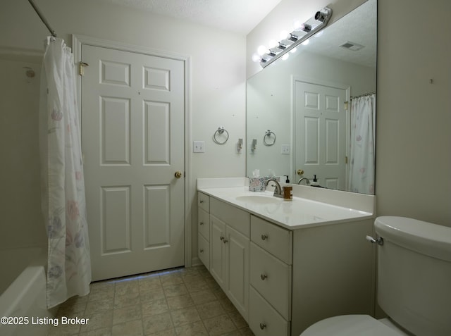 bathroom with visible vents, vanity, toilet, and a textured ceiling